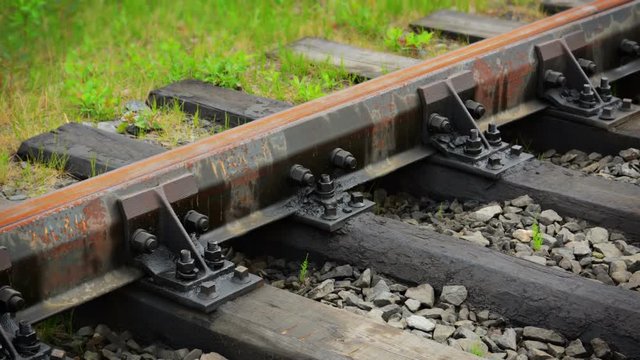 UltraHD video - Steel rails, bolted to creosote-coated wooden ties in a coarse gravel bed comprise a section of railroad in the Russian countryside.