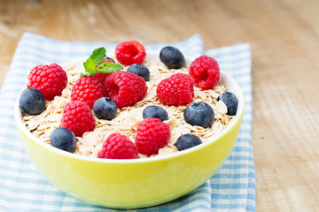 Oatmeal porridge with berries. Raspberries and blueberries.