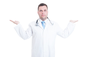 Young male doctor holding copyspace with two hands isolated