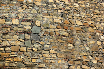 Old stone fortress wall mosaic background. Granite rock boulder