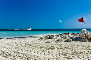Fototapeta premium White sandy beaches and beach flag and boat at Cancun