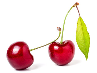 Two cherries with leaf closeup isolated on white background