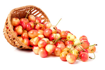 yellow cherries in a wicker basket isolated on white background