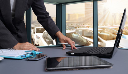 bussiness man working in office with  New Cars in Stock. Car Dealership Cars For Sale background © sittinan