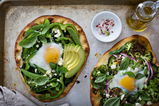 Breakfast pizza with baked egg and greens