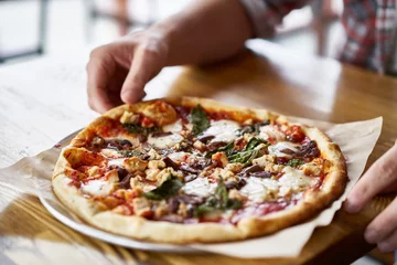 Crédence de cuisine en verre imprimé Pizzeria hand reaching to take slice of pizza