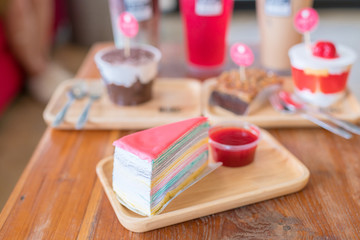 Crepe cake with strawberry sauce on wood table