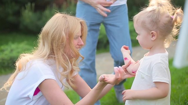 Mom plays with a daughter covered in paint.
