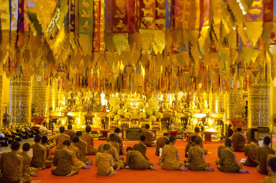 Rear view of monks sitting in Wat Chedi Luang temple