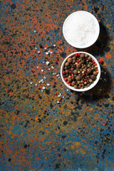 assortment of pepper and sea salt in bowls and dark background