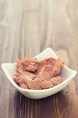 pork pate in bowl on brown wooden background