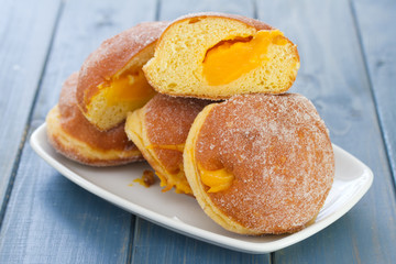 donuts on white dish on blue wooden background