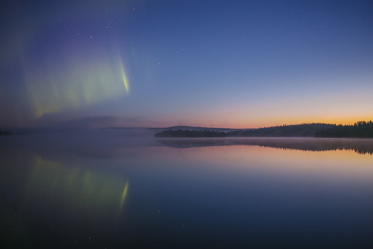Aurora borealis over tranquil lake, Finland  