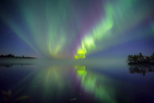 Aurora borealis above lake, Finland.