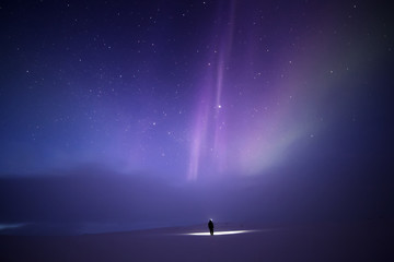 Person bathed in light from Aurora borealis, Finland