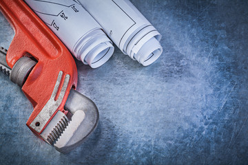 Monkey wrench rolled engineering drawings on metallic background