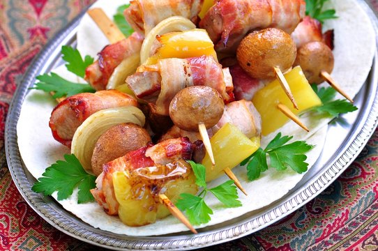 Pork wrapped in bacon on skewers grilled with onions, mushrooms and peppers.
