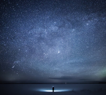 Man standing against milky way in the sky during winter