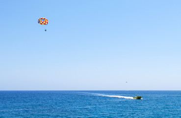 Photo of sea in protaras, cyprus island with parasailing and a boat.