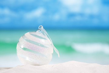  christmas glass ball on white sand beach with seascape backgrou