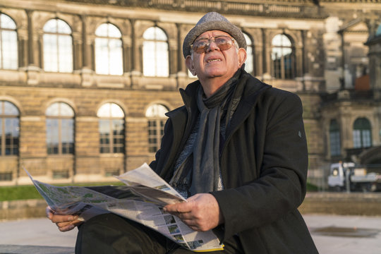 Germany, Dresden, senior man with newspaper looking up