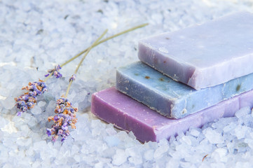 Natural soap, lavender, salt on a wooden board, hygiene items for bath and spa.