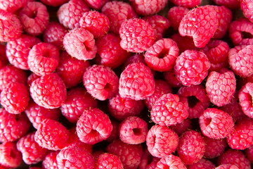 Ripe sweet juicy raspberries on wooden table. Close up, top view