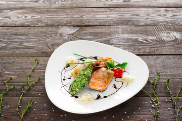 Mussle, grilled salmon, shrimp on wood copyspace. White plate with variety of seafood on wooden background. Free space and seafood mix plate.