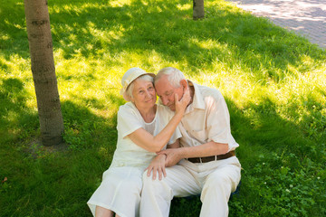 The happy old couple in the summer on a walk