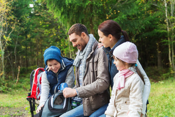 happy family with backpacks and thermos at camp