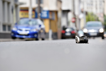 Shoe on the street with cars in background after accident