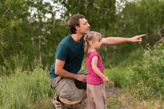 Father And Daughter Walking On A Hill