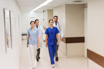 group of medics or doctors walking along hospital