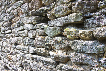 Detail of an old stone wall. Medieval wall consumed by time