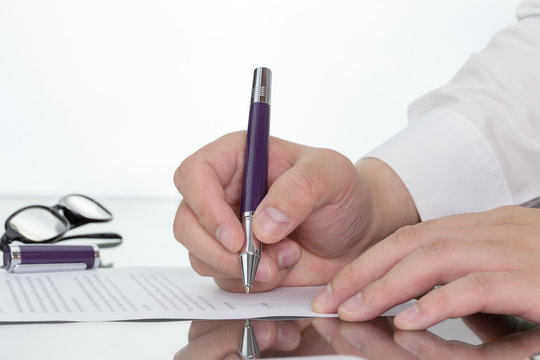 Businessman working on digital tablet on his desk with hand holding pen reflection.