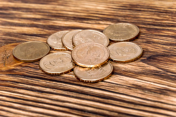 heap of dollar coins on wooden background