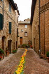 Street in the old town of Pienza, in Italy, decorated with flowe