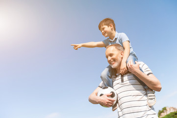 Cute grandson and grandparent are playing in park