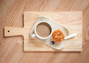 Table Top View of Hot Coffee and Coffee Almond Cup Cake on Woode