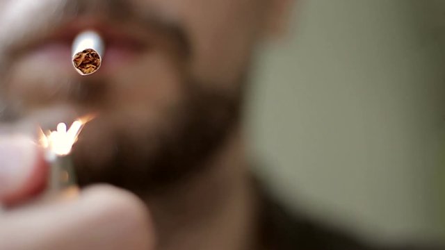 Young man lighting up a cigarette