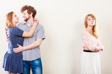 Abandoned woman with enamored couple