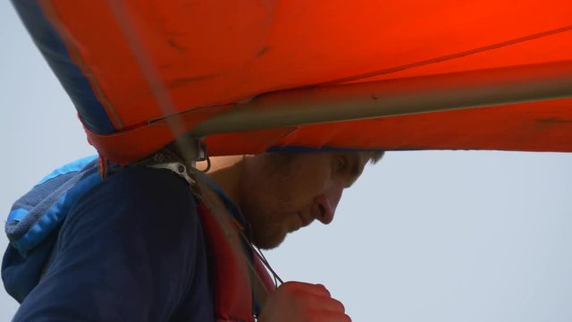 Man holds the nose of the hangglider