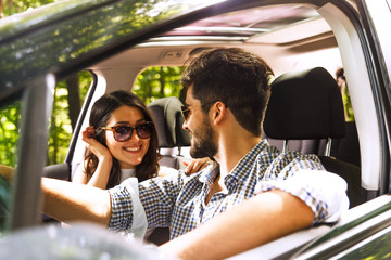 Portrait of young couple driving a car.