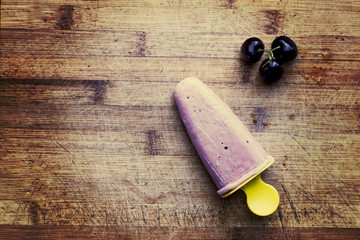 Homemade fresh cherry popsicle with berries on wooden cutting board. Toned image. Top view. Summer food concept. - Powered by Adobe
