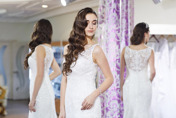 Naklejka premium Female trying on wedding dress in a shop.