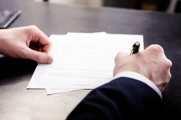 Business man signing the contract - shallow focus on signature