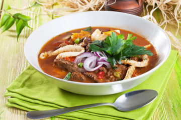 Lagman with meat clay pot wooden board still life green bright beautiful appetizing, delicious food