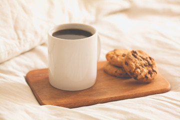 Chocolate Chip Cookies and Tea in bed. Selective focus. Toned photo.