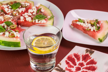 Cut watermelon pizza with crumbled feta cheese and prosciutto and basil.