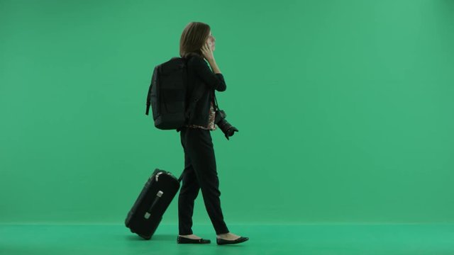 female tourist with camera walks talking on the phone